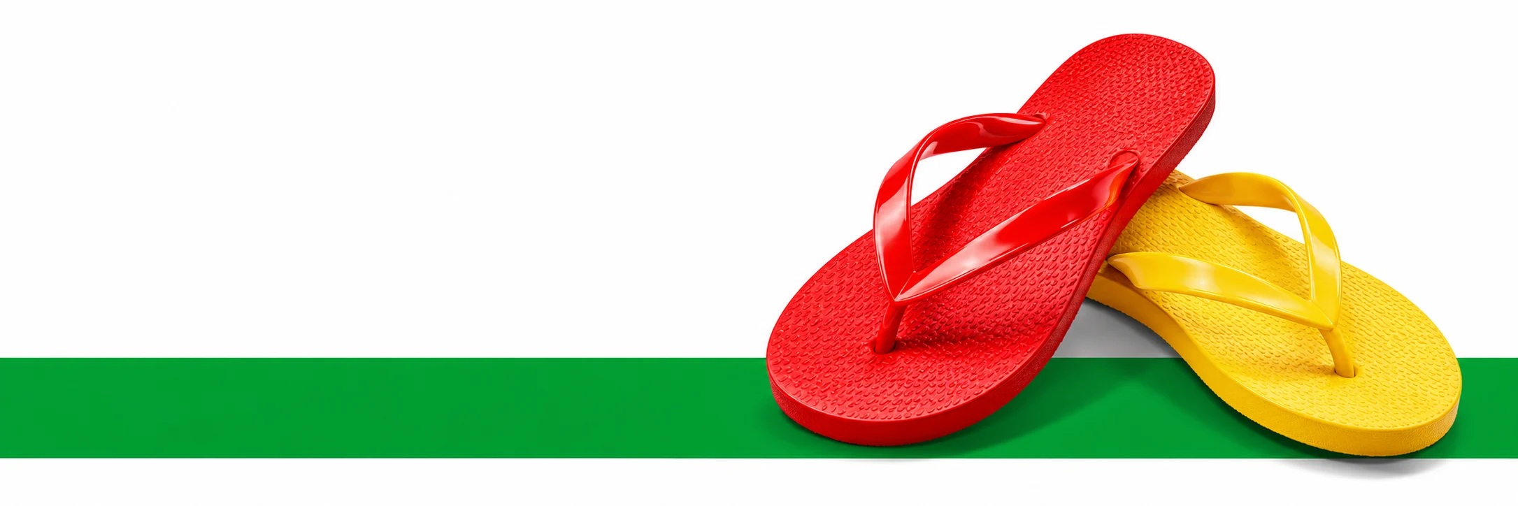 Chinelos vermelho e amarelo sobre uma faixa verde